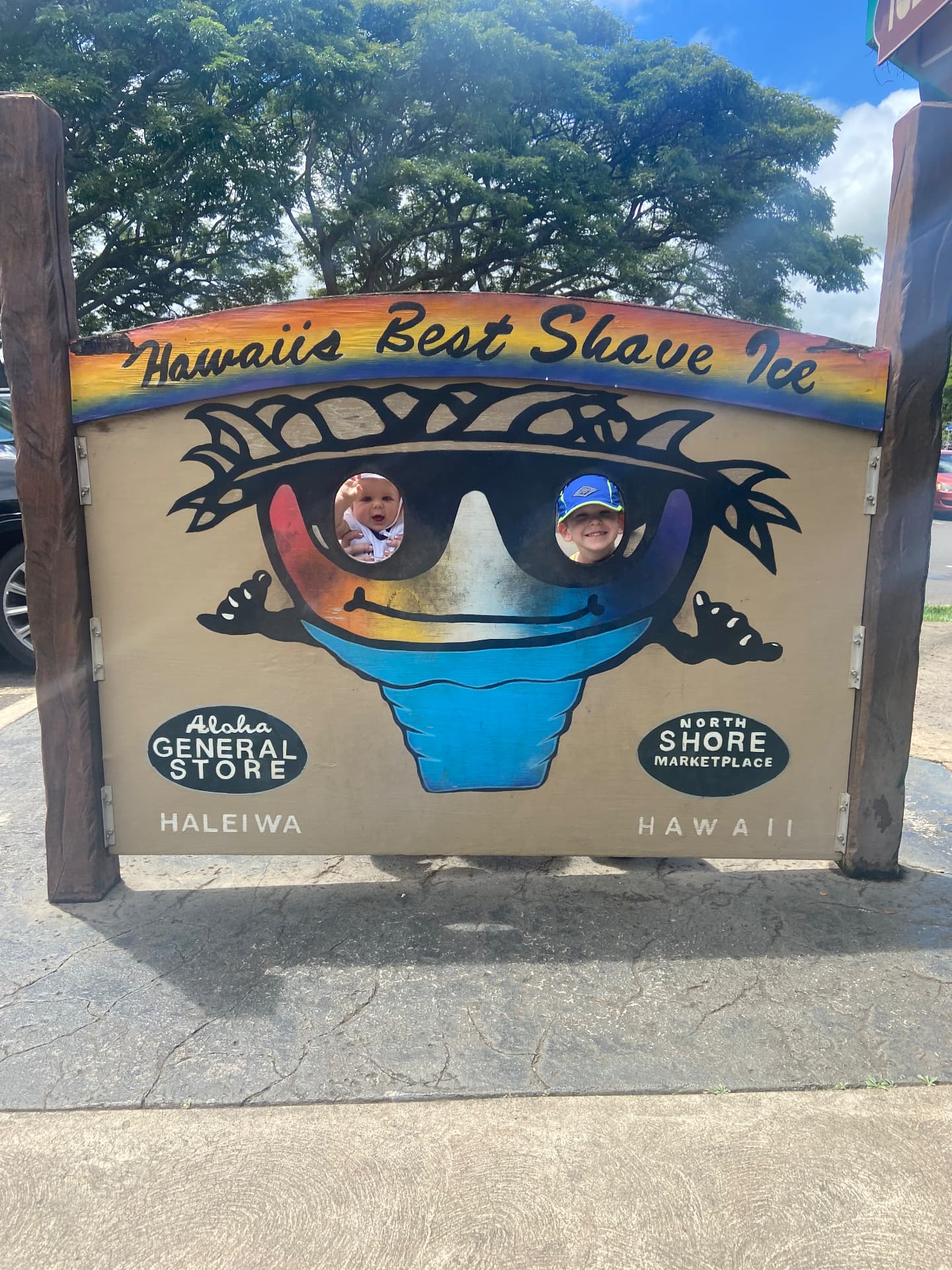 Kids peeking through a colorful shave ice stand in Haleiwa, North Shore Oʻahu